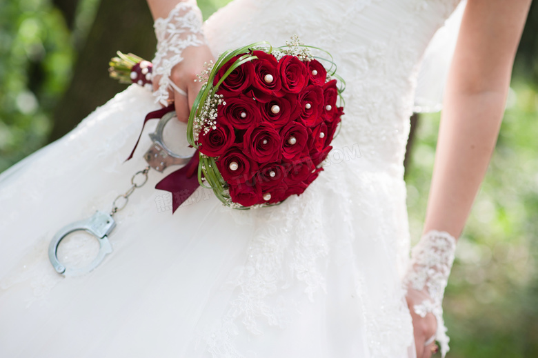 拿着红玫瑰花束的新娘局部摄影图片