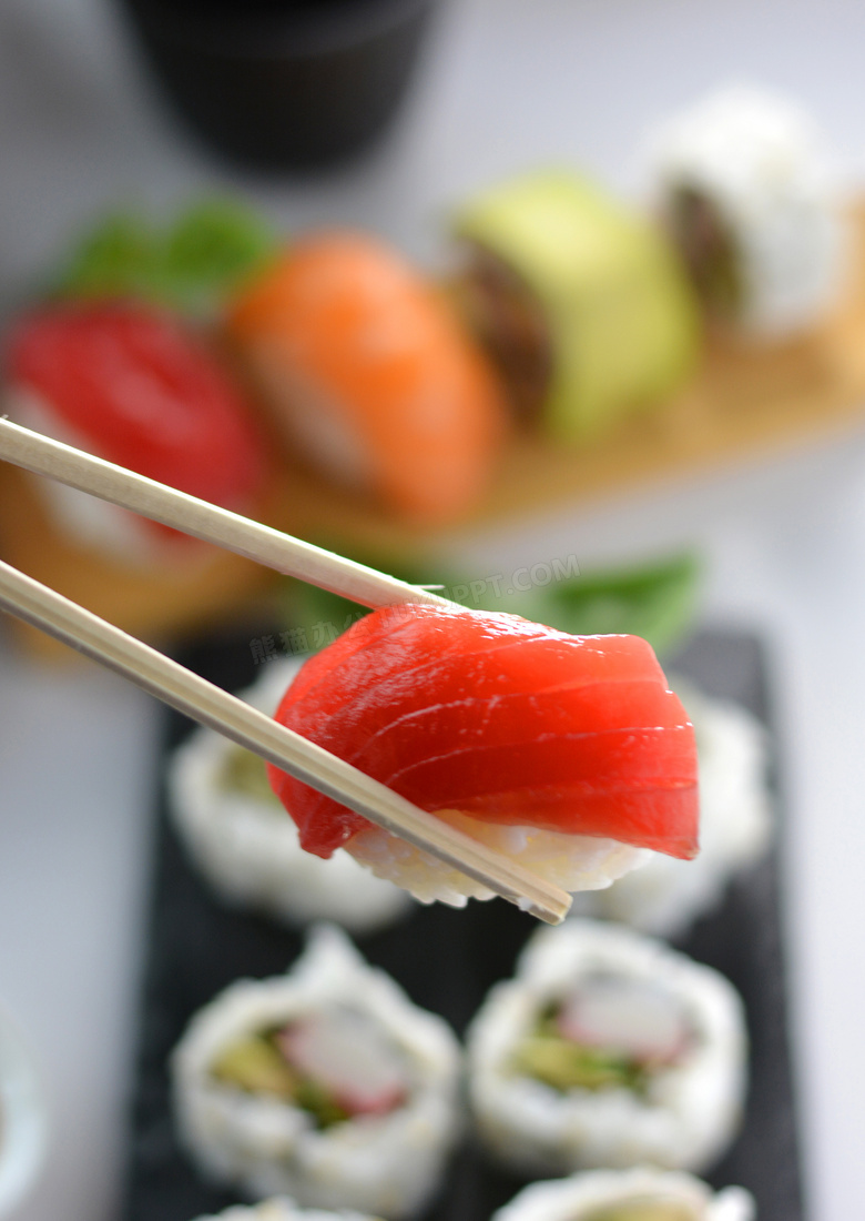 被筷子夹着的一块寿司摄影高清图片