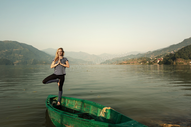 单腿站在木船上的美女摄影高清图片