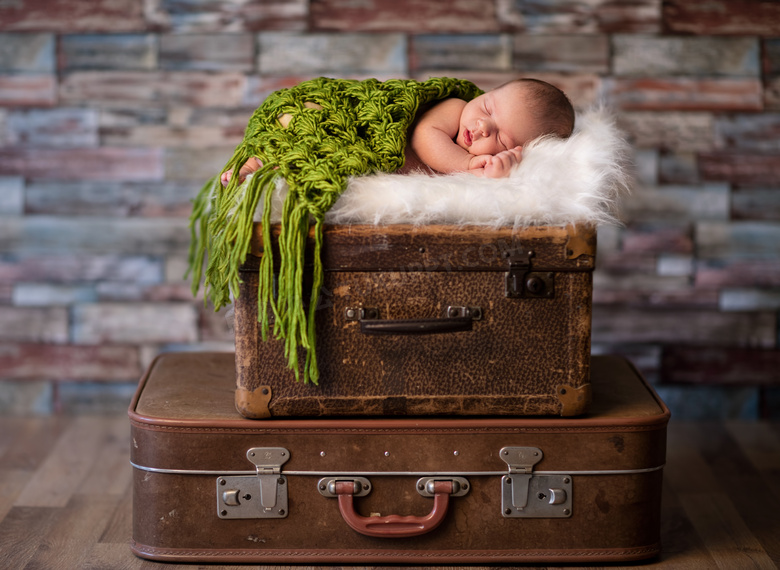 躺在皮箱上睡觉的宝宝摄影高清图片