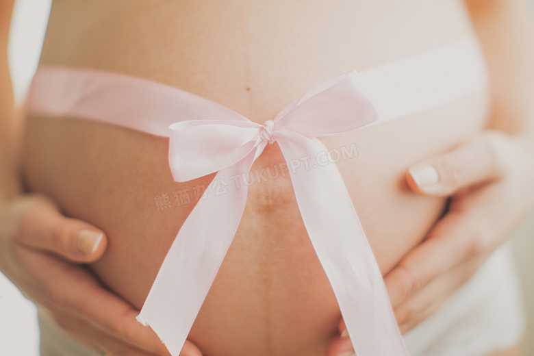 在腹部系着丝带的孕妇特写摄影图片
