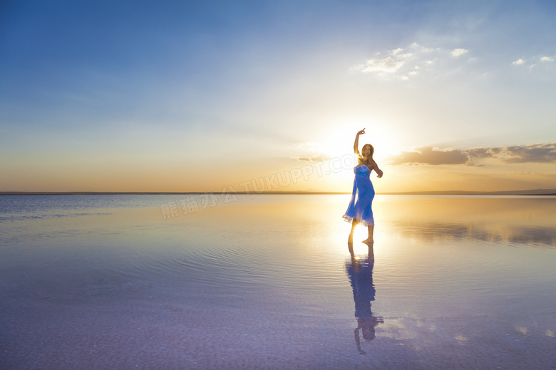 在海边翩翩起舞的蓝裙女子高清图片