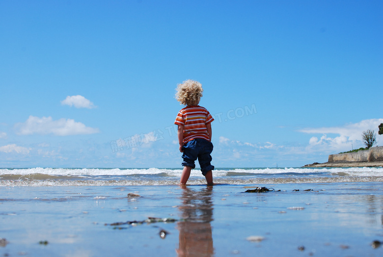 海边卷起裤管的小男孩摄影高清图片