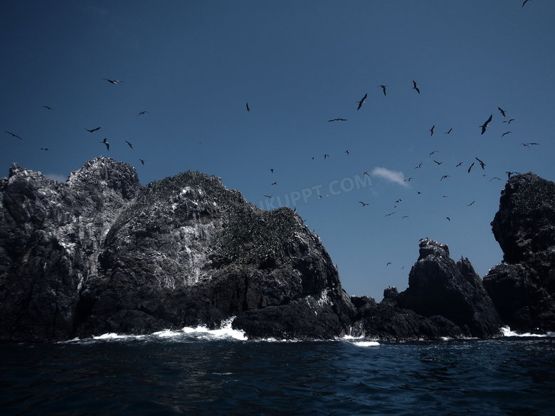 蓝天山石与飞翔的海鸟摄影高清图片