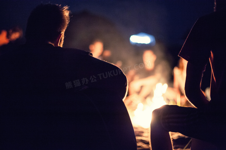 围着篝火而坐的露营人摄影高清图片