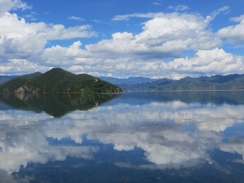蓝天下的泸沽湖美丽倒影摄影图片