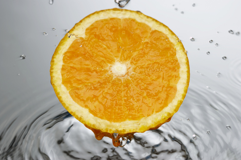 切开的橙子与水面涟漪摄影高清图片