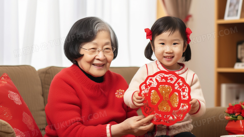寒假春节可爱的女孩和奶奶一起剪窗花过新年