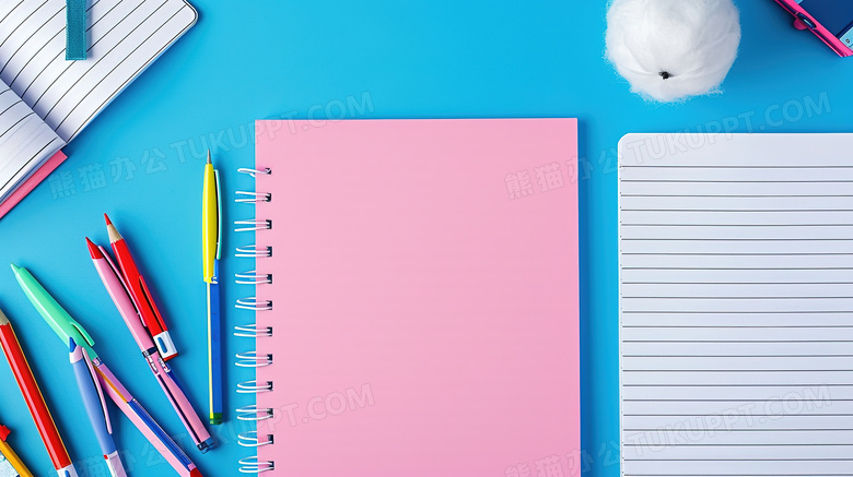 蓝色桌面上摆放着粉色笔记本和铅笔文具图片