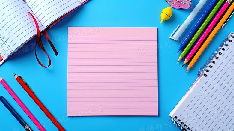 蓝色桌面上摆放着粉色笔记本和铅笔文具图片