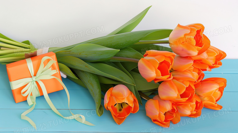 桌面上的橙色郁金香花束和礼盒图片