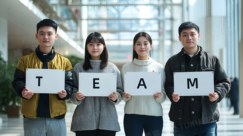 手拿TEAM字母牌的四个商务人士图片