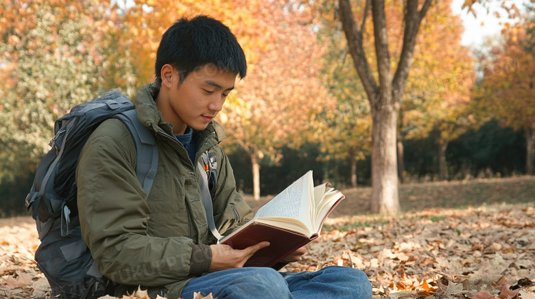 校园内草坪上看书的男学生图片