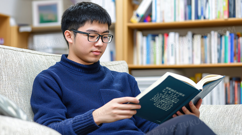 坐在沙发上看书的男学生图片