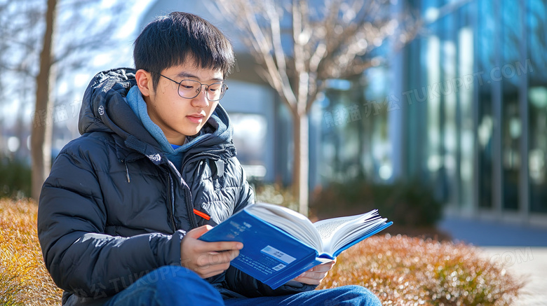 校园内拿着书本看书的男人图片