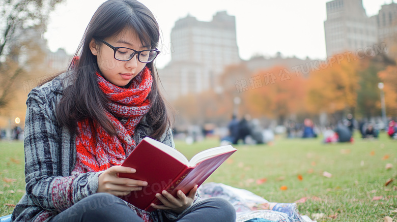 草坪上阅读书本的女学生图片