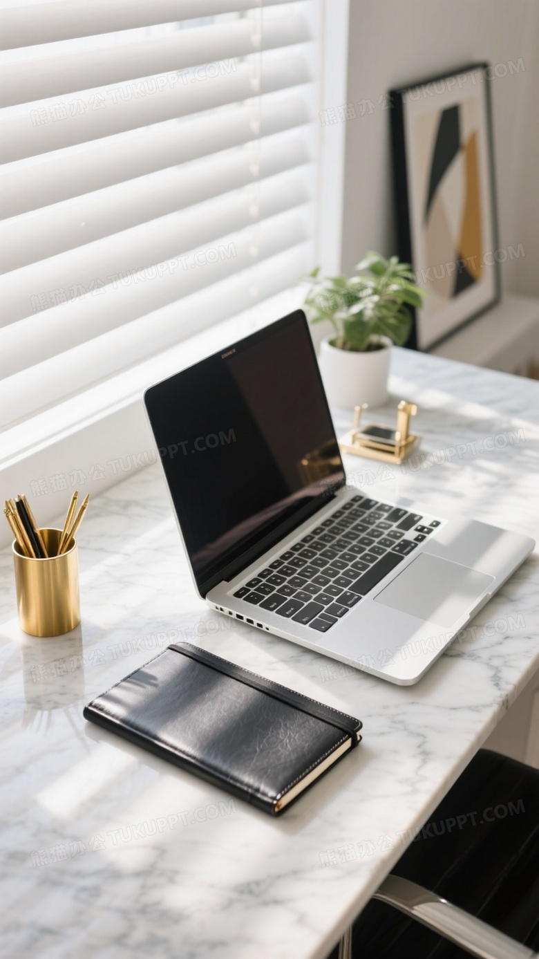 现代极简办公桌俯拍银色笔记本电脑与黑色皮质笔记本并置