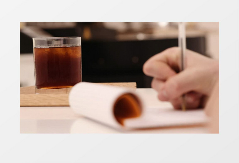 高清实拍一个人在放着咖啡的桌子上写笔记实拍视频素材