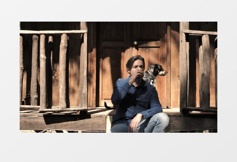 年轻男子和他的狗在门口晒太阳实拍视频素材