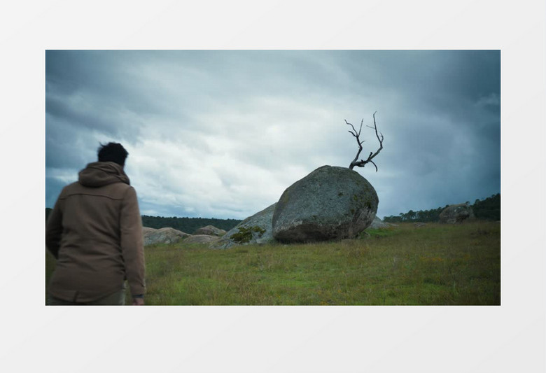 男人走向一块大石头拿出手机拍照实拍视频素材