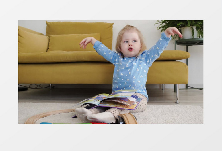 可爱的小女孩坐在地毯上看画册实拍视频素材
