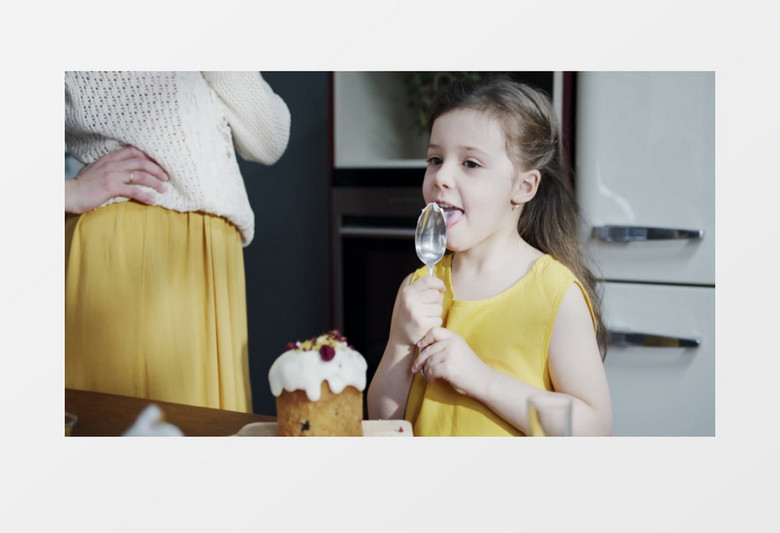 小女孩在舔勺子上的奶油实拍视频素材
