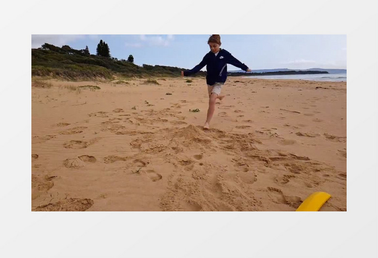 小男孩在海边踢散小沙丘实拍视频素材