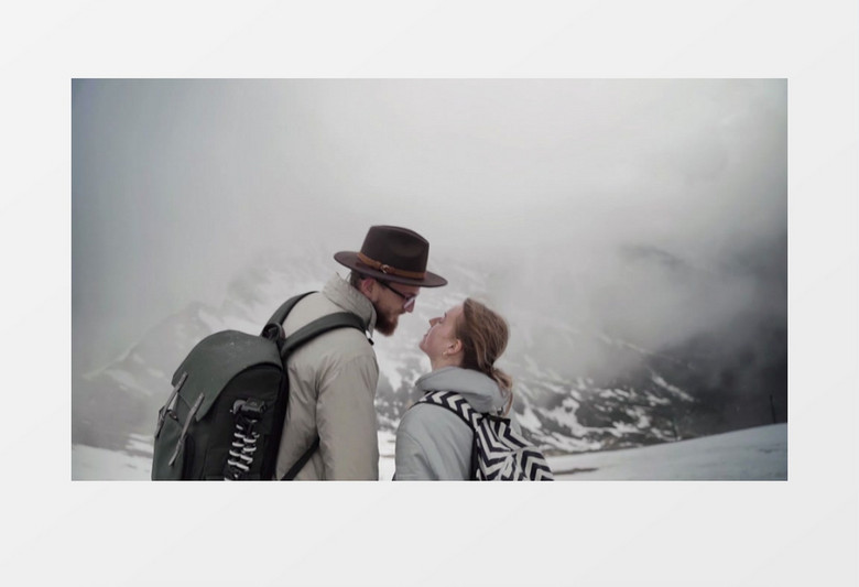 一对情侣在雪山顶牵手接吻实拍视频素材