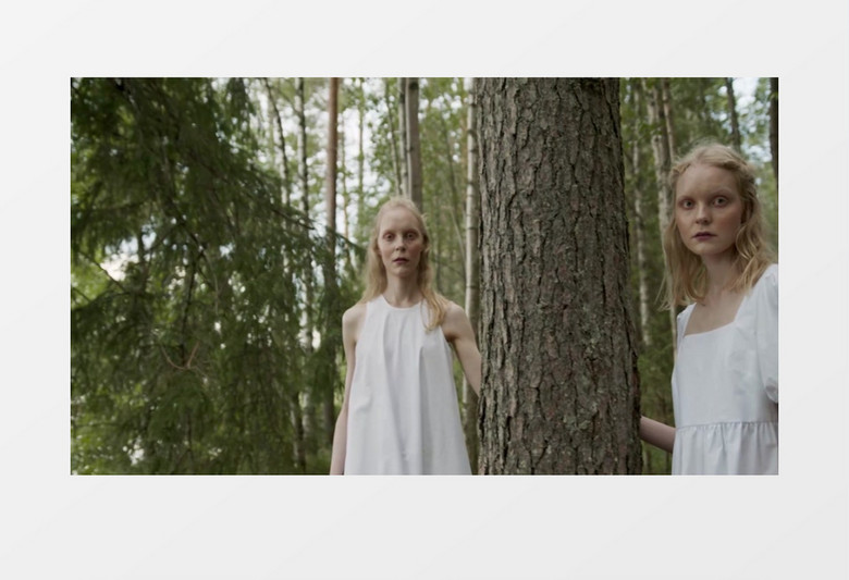 两个穿着白裙子的模特在树林中行走实拍视频素材