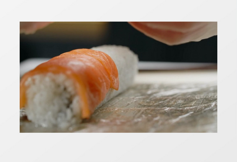 料理师在米饭卷上铺三文鱼实拍视频素材