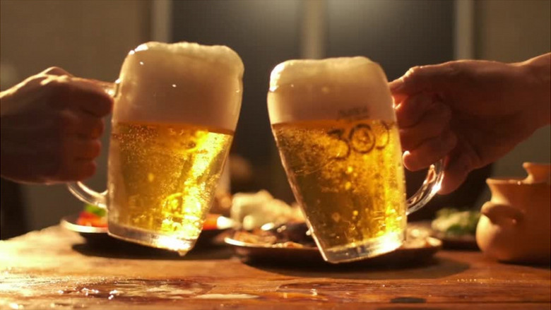 两个人端着两杯啤酒碰杯实拍视频素材