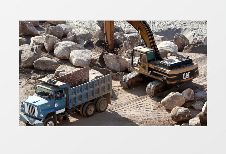 挖掘起重机把石头送到卡车上实拍视频素材