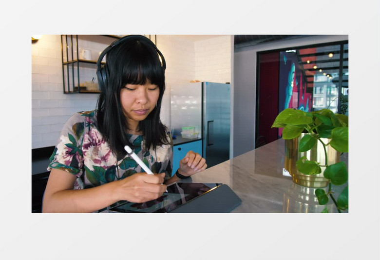 一个年轻的女子 在餐桌上用平板电脑工作实拍视频素材