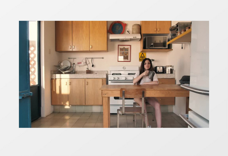 女子早上在厨房喝咖啡她的女朋友亲了她实拍视频素材