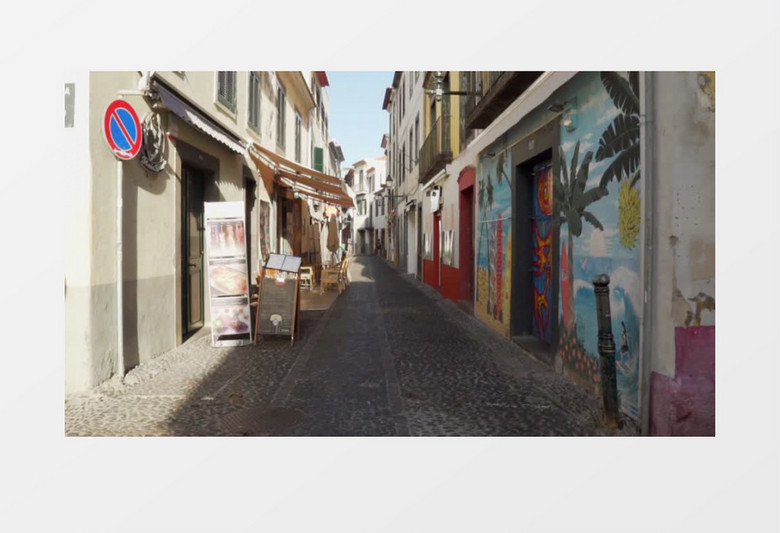 一条铺满鹅卵石的小巷墙上有涂鸦壁画实拍视频素材