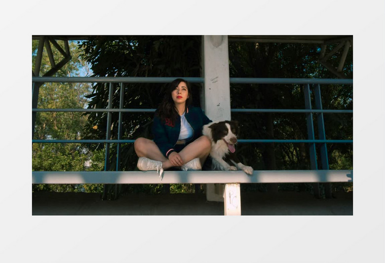 一个女人和她的狗坐在石台上实拍视频素材