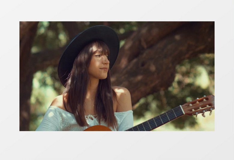 弹吉他的漂亮女孩对着镜头微笑实拍视频素材