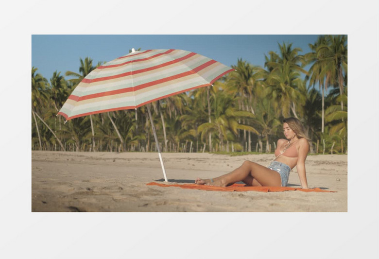 苗条女孩穿着比基尼在海边晒太阳实拍视频素材