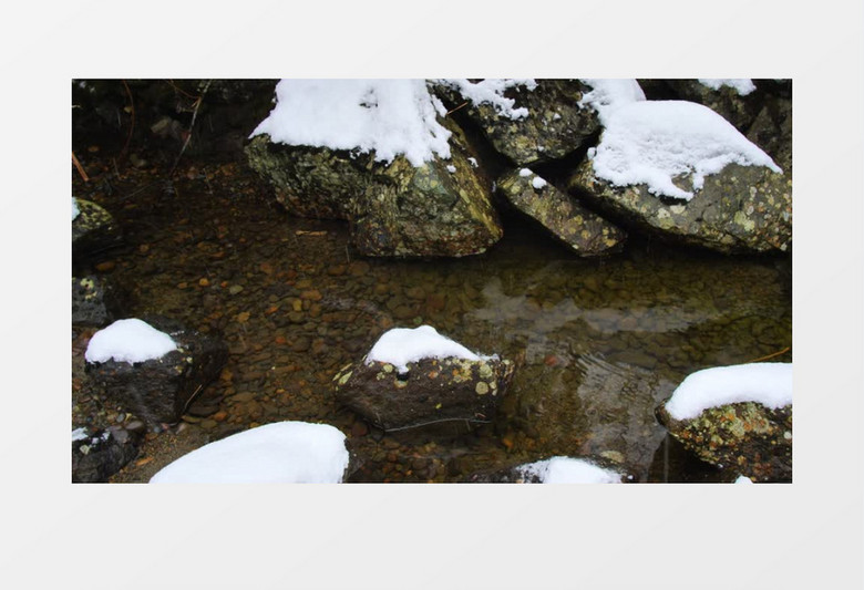 冬天溪水中的石块上覆盖着白雪下着小雪实拍视频
