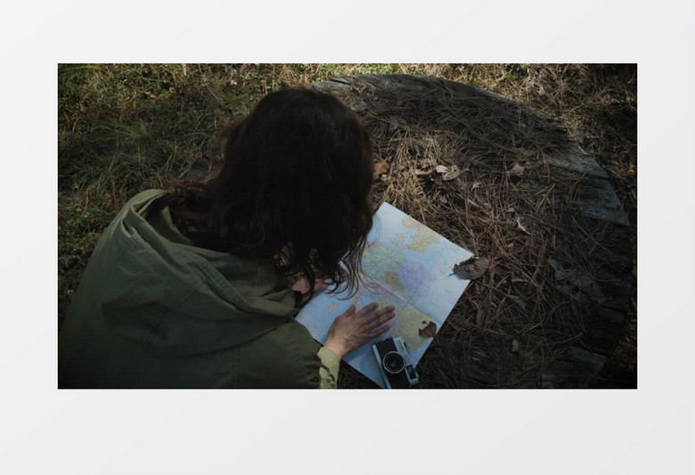 趴在草地上看地图的女人实拍视频素材
