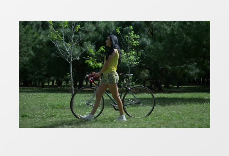  漂亮女孩子推着自行车在草坪上实拍视频素材