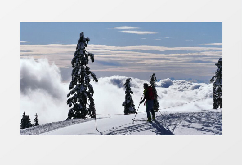 滑雪者在白雪皑皑的山顶边缘行走实拍视频素材