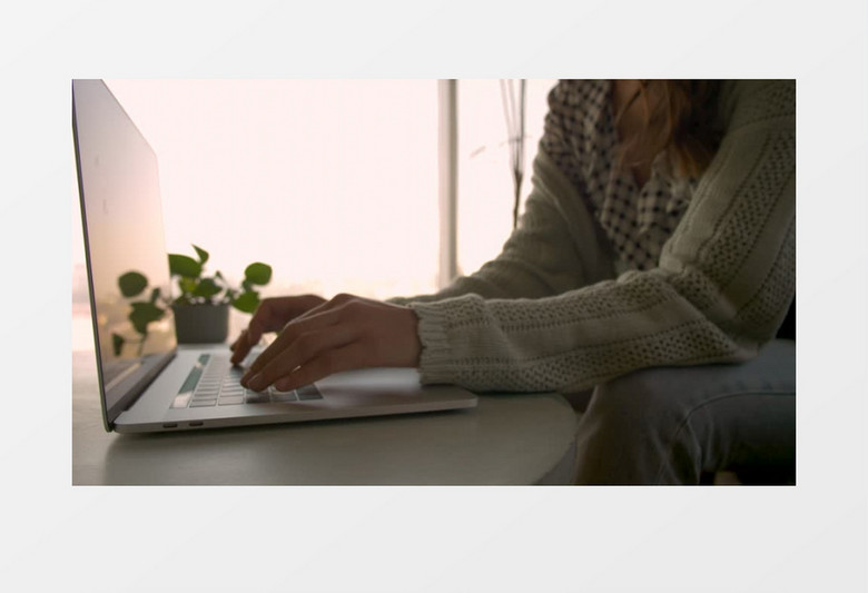 高清拍摄一个穿着毛衣的女人用笔记本电脑工作实拍视频素材