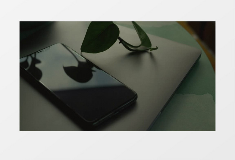 一个黑色的手机放在一个笔记本电脑上实拍视频素材