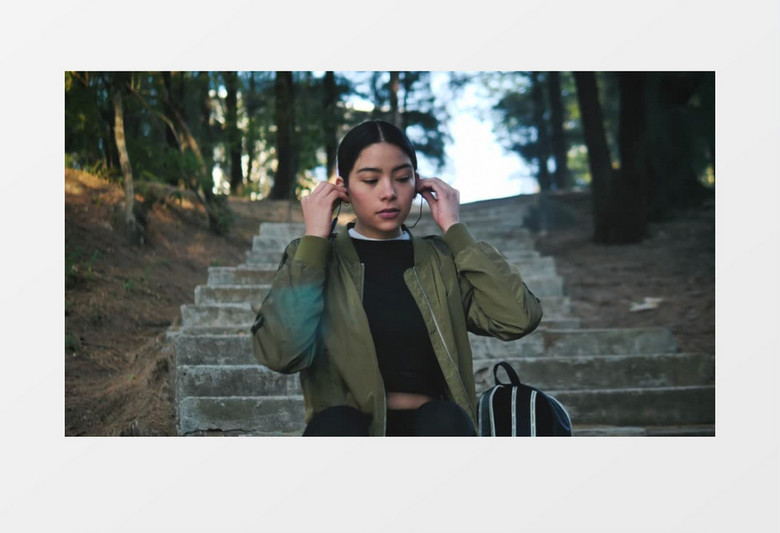 近景拍摄穿着运动服的女人戴上耳机听音乐实拍视频素材