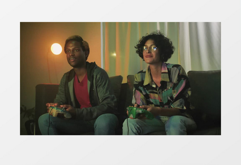 正面拍摄夫妇在沙发上愉快地玩电子游戏实拍视频素材