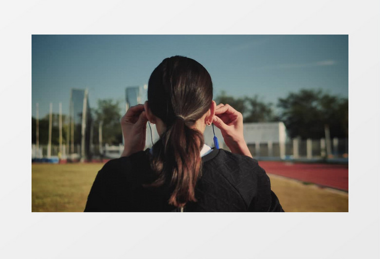 一个女人调整耳机开始跑步实拍视频素材