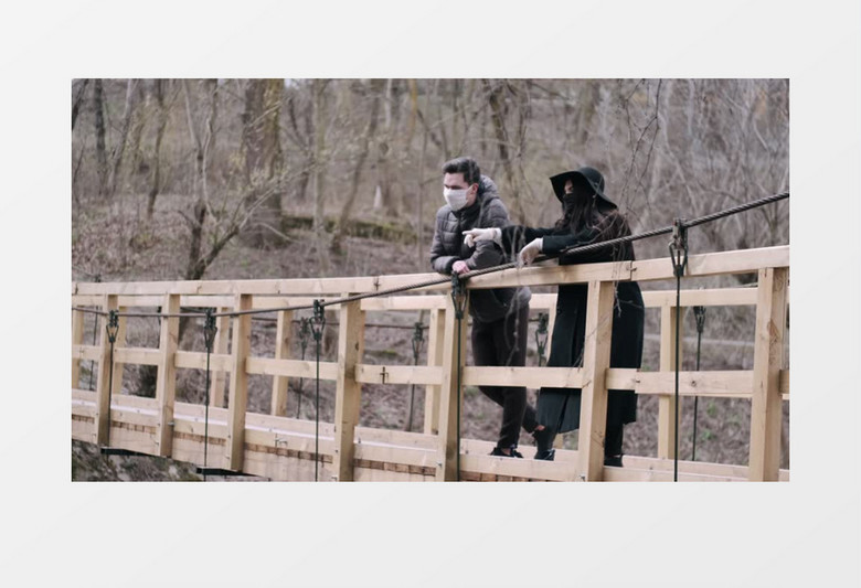 一对情侣带着口罩站在木桥上看风景实拍视频素材