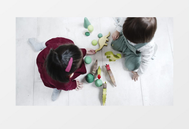 俯拍两个小朋友在地板上玩陀螺实拍视频素材