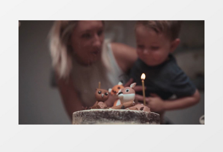 妈妈帮男孩吹灭生日蛋糕蜡烛实拍视频素材
